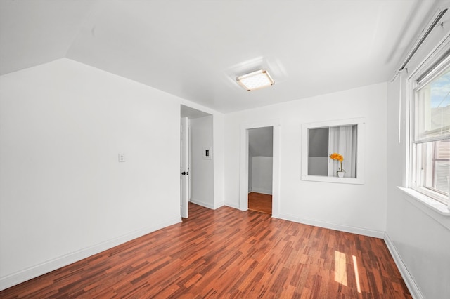 spare room featuring hardwood / wood-style flooring and vaulted ceiling