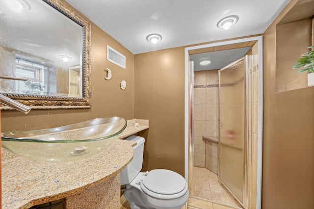 bathroom featuring vanity, a shower with shower door, tile patterned flooring, and toilet