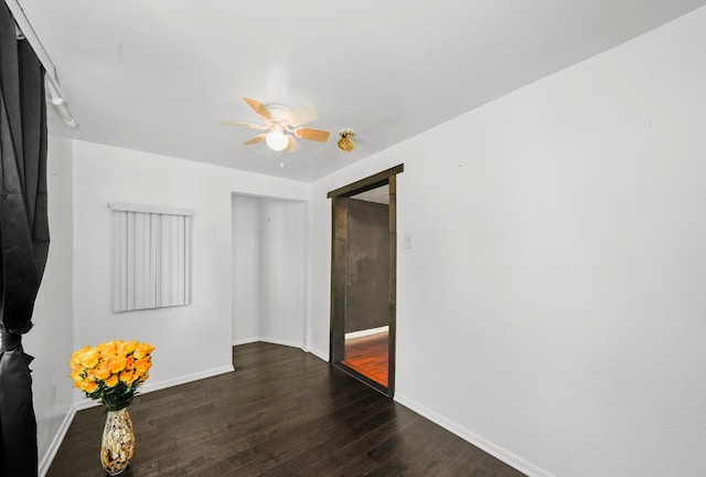 spare room with dark wood-type flooring and ceiling fan