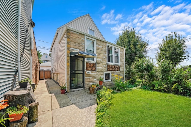 rear view of property featuring a lawn and a patio area