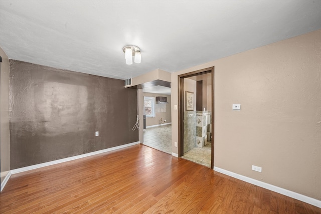 empty room featuring hardwood / wood-style floors and a wall mounted AC