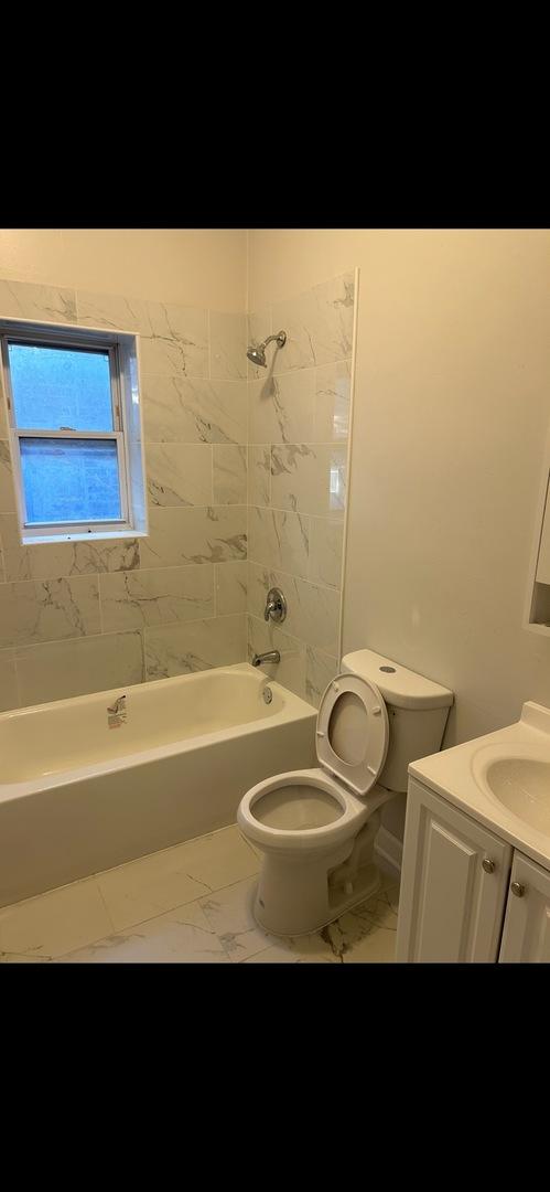 bathroom with marble finish floor, bathtub / shower combination, toilet, and vanity