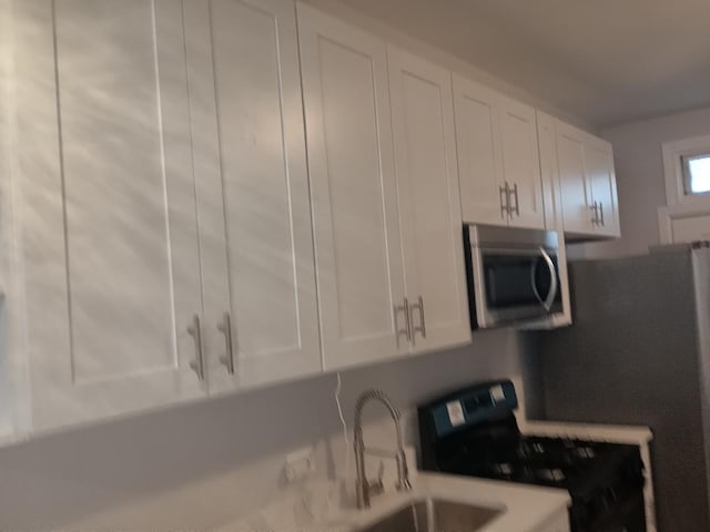 kitchen featuring white cabinetry, light countertops, and appliances with stainless steel finishes