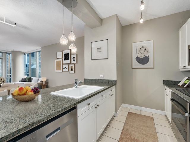 kitchen featuring white cabinetry, sink, stainless steel dishwasher, oven, and pendant lighting