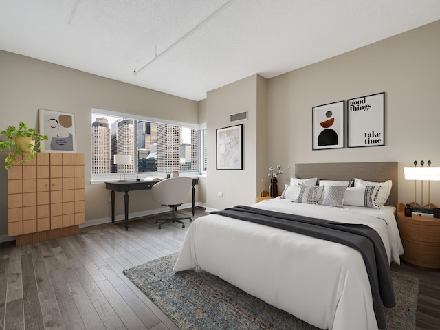 bedroom with wood-type flooring and a textured ceiling