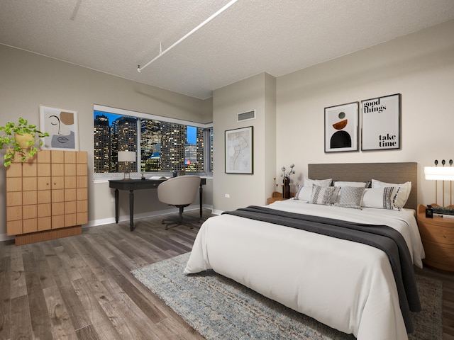 bedroom with hardwood / wood-style floors and a textured ceiling