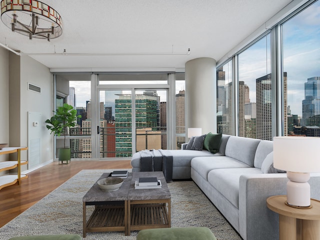 living room with expansive windows, hardwood / wood-style flooring, plenty of natural light, and a textured ceiling