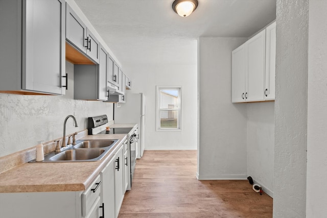 kitchen featuring light hardwood / wood-style floors, stainless steel electric range, and sink