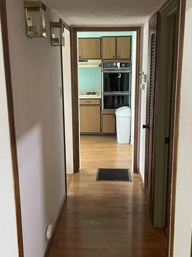 corridor with hardwood / wood-style floors