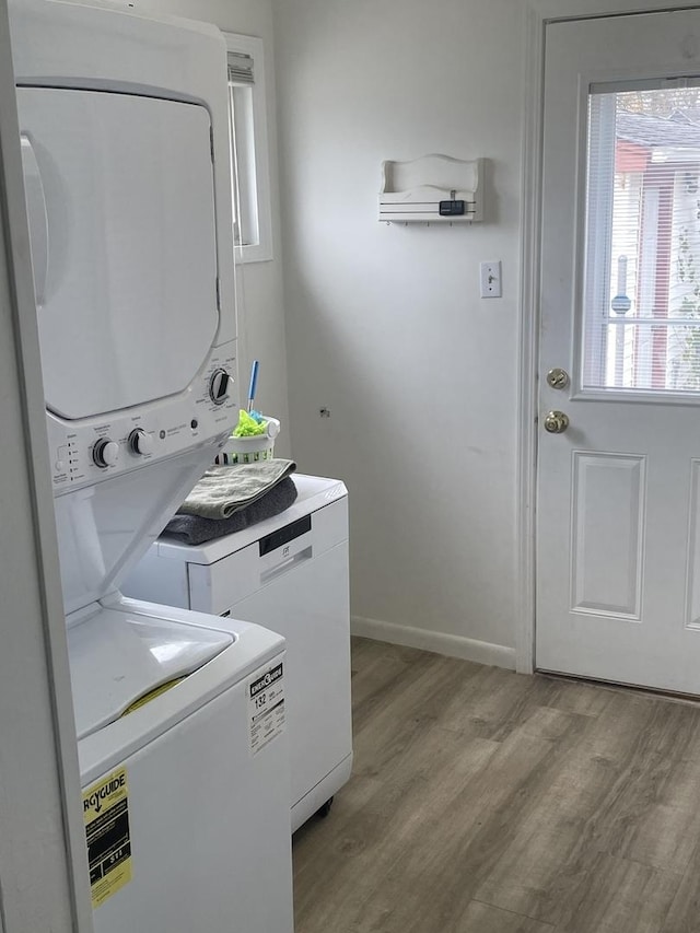 washroom with light wood-type flooring and stacked washer and dryer