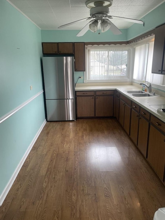 kitchen featuring dark hardwood / wood-style flooring, stainless steel refrigerator, ceiling fan, and sink