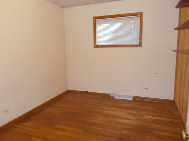 unfurnished room with hardwood / wood-style flooring