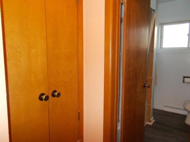 interior space with dark hardwood / wood-style floors and a baseboard heating unit