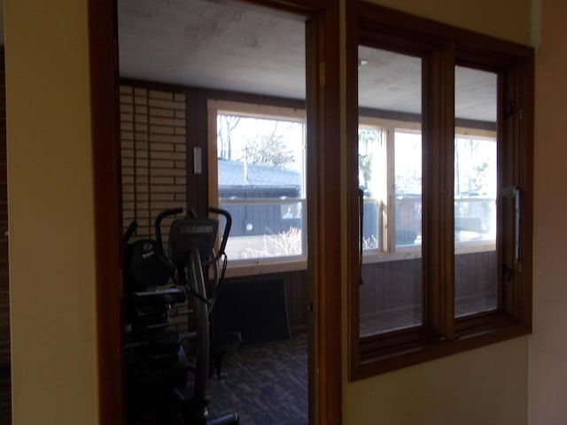 doorway to outside with a textured ceiling