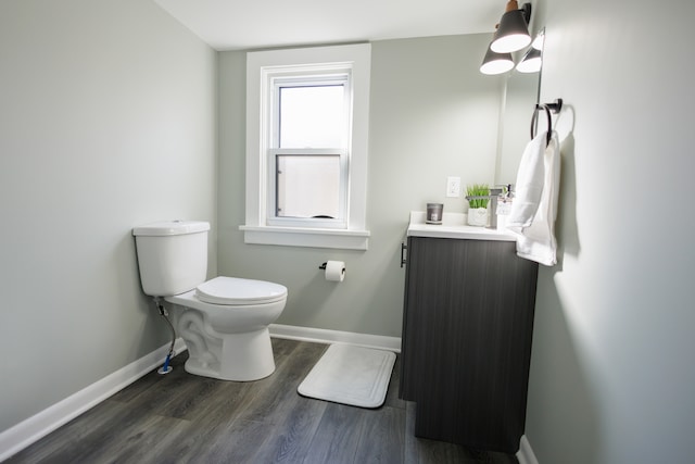 bathroom with hardwood / wood-style floors, vanity, and toilet