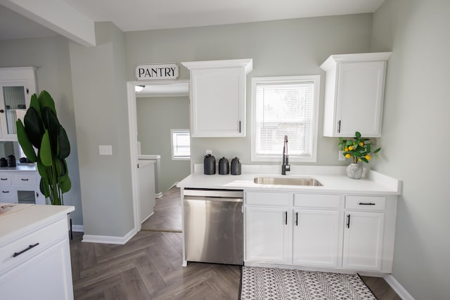 kitchen featuring dishwasher, dark parquet floors, sink, and white cabinets