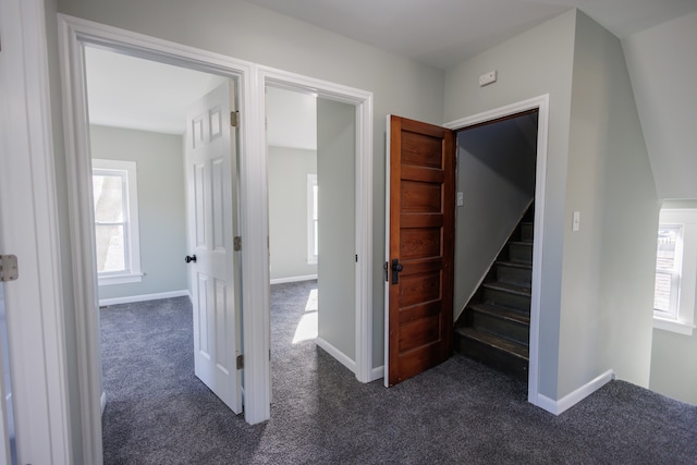 hall with dark colored carpet