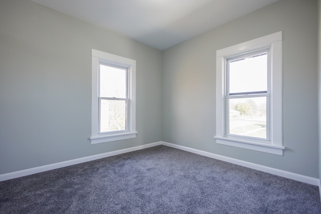 unfurnished room with dark colored carpet