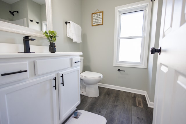 bathroom with hardwood / wood-style floors, plenty of natural light, toilet, and vanity