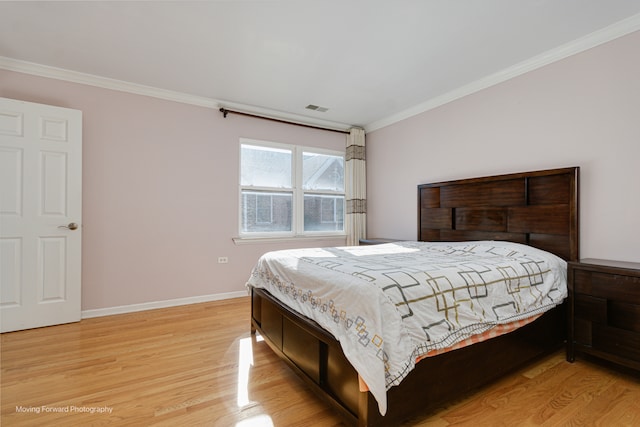 bedroom with light wood-type flooring and crown molding