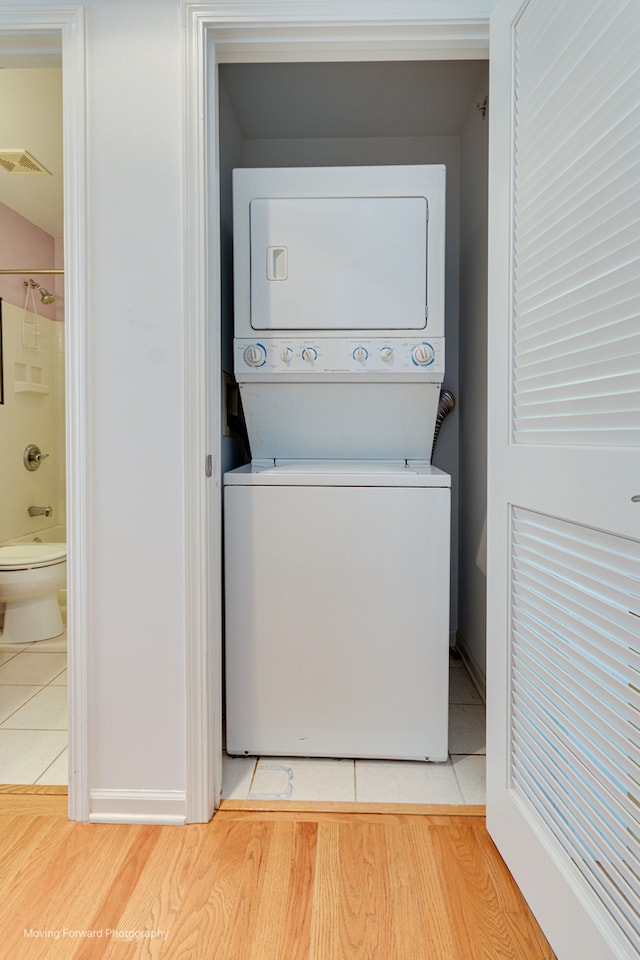 washroom featuring stacked washer / dryer and light wood-type flooring