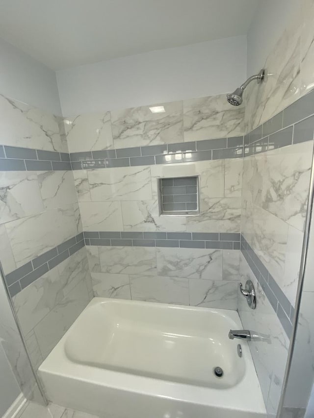 bathroom featuring tiled shower / bath