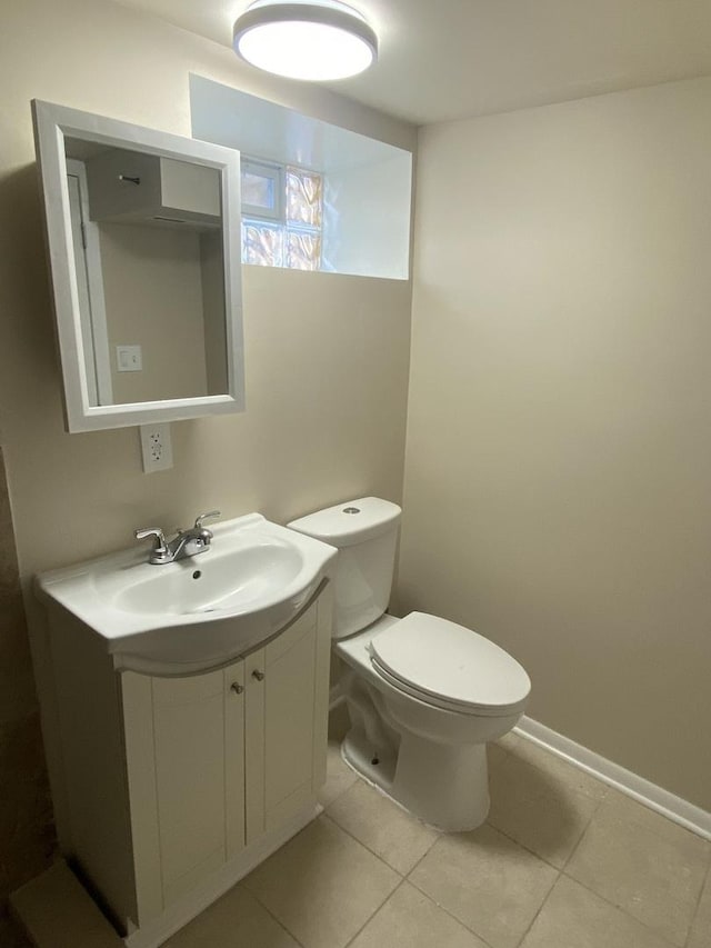 bathroom with toilet, vanity, and tile patterned flooring