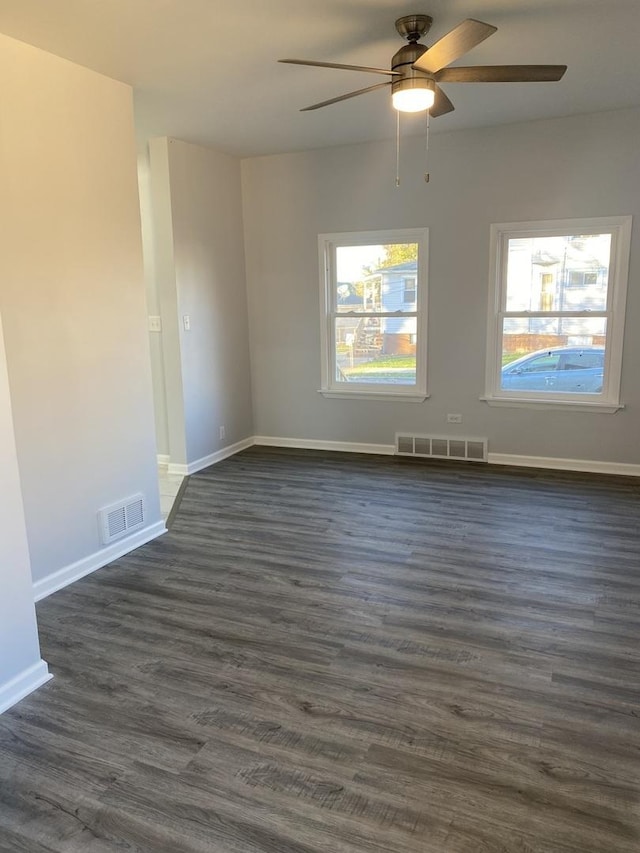 unfurnished room with ceiling fan and dark wood-type flooring