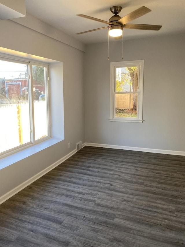 empty room with ceiling fan and dark hardwood / wood-style flooring