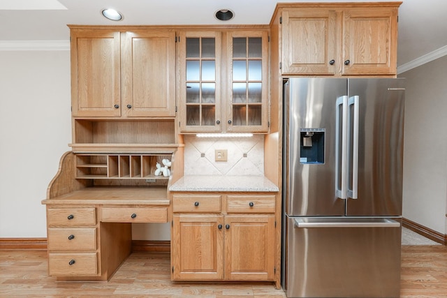 kitchen with crown molding, stainless steel fridge, tasteful backsplash, light brown cabinetry, and light wood-type flooring