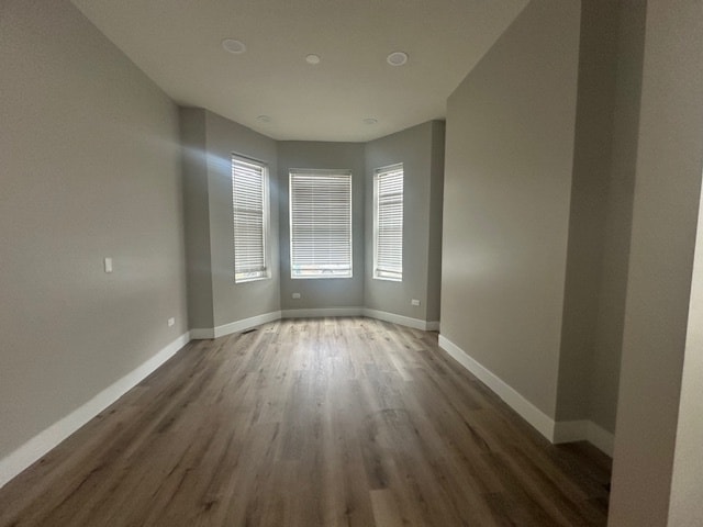 unfurnished room with dark hardwood / wood-style flooring