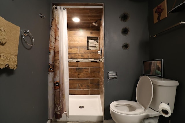 bathroom with curtained shower and toilet