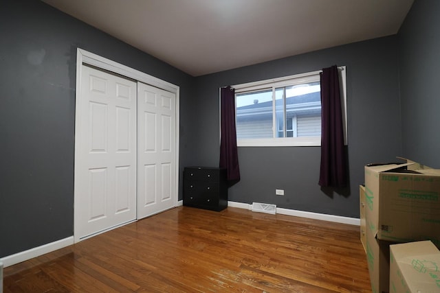 unfurnished bedroom featuring a closet and hardwood / wood-style flooring