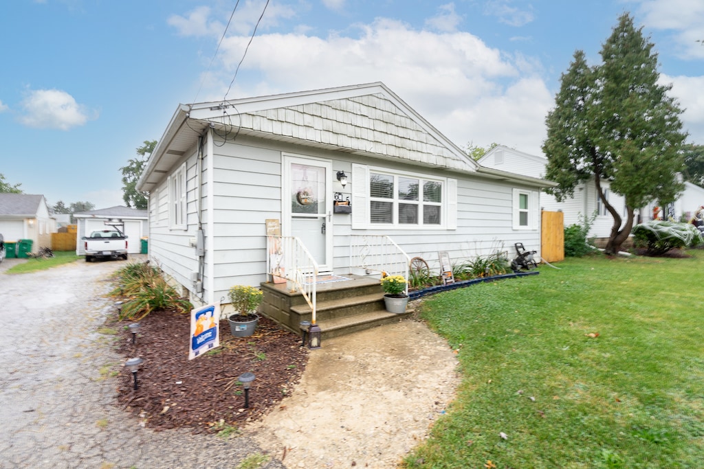 bungalow-style home with a front yard