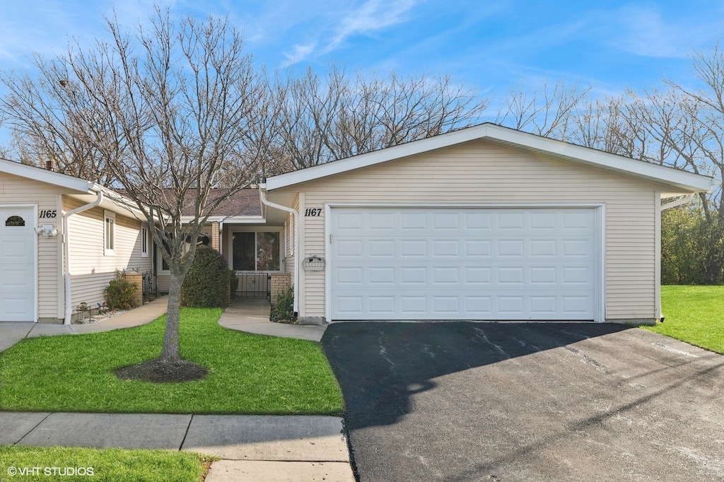 single story home with a garage and a front lawn