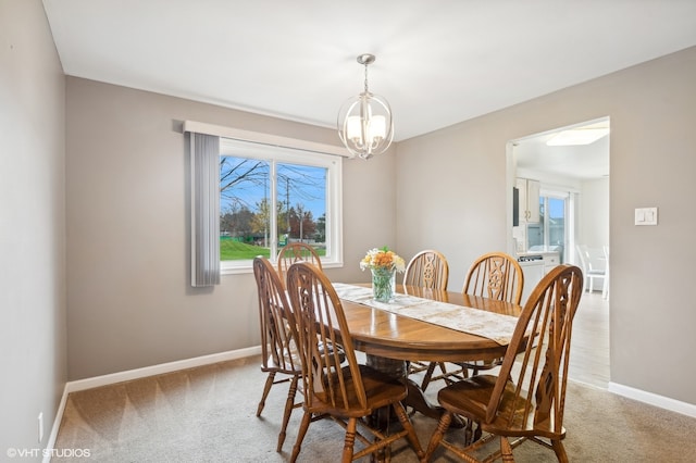 carpeted dining space with a chandelier