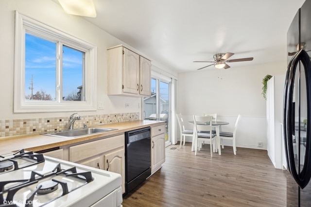 kitchen featuring tasteful backsplash, ceiling fan, dark wood-type flooring, sink, and black appliances