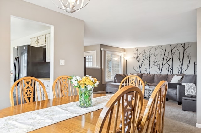 dining space featuring light hardwood / wood-style floors and a notable chandelier