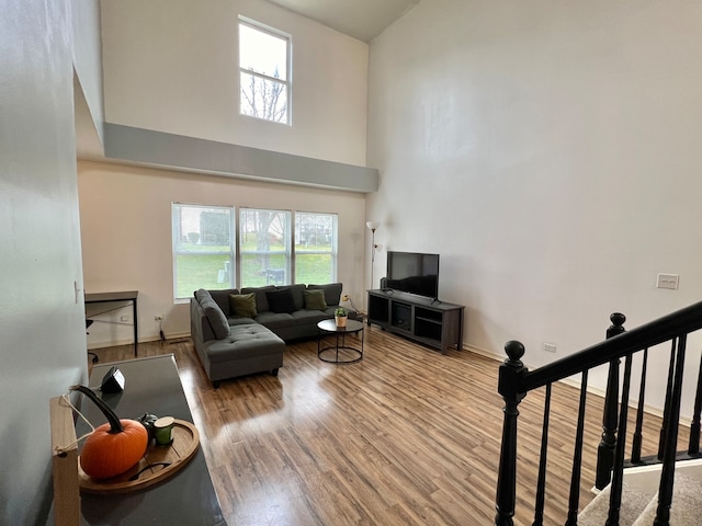 living room featuring light hardwood / wood-style floors and a high ceiling