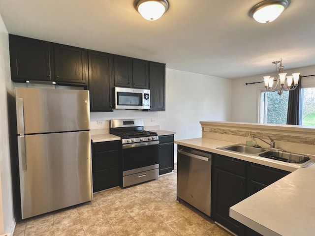 kitchen featuring pendant lighting, sink, a chandelier, and appliances with stainless steel finishes