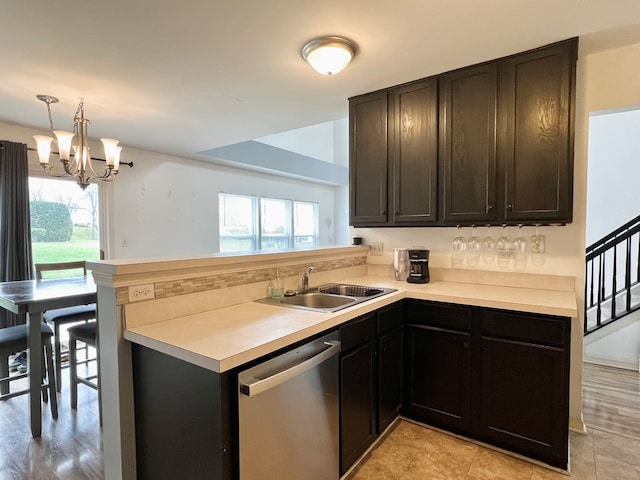 kitchen featuring dishwasher, sink, a wealth of natural light, and an inviting chandelier