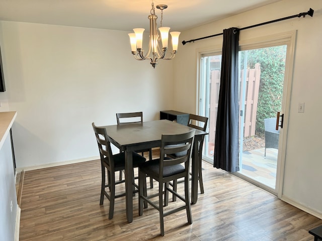 dining area featuring hardwood / wood-style flooring and a chandelier