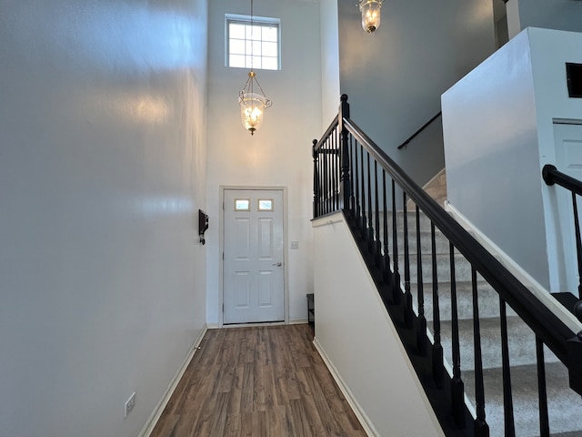 doorway with a high ceiling and hardwood / wood-style flooring