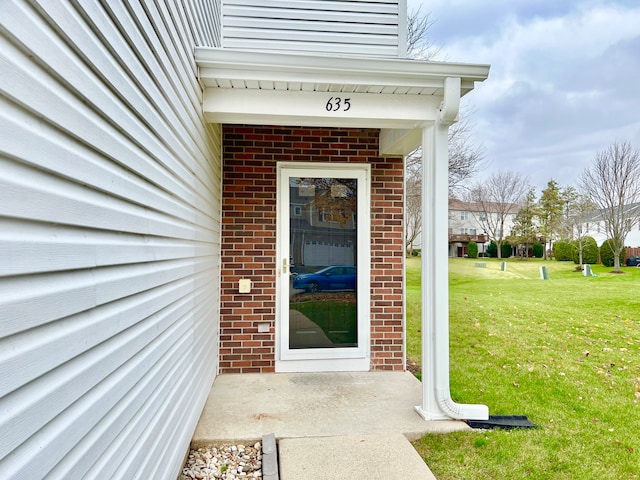 view of exterior entry featuring a yard