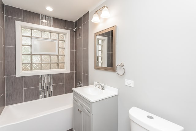 full bathroom featuring vanity, a healthy amount of sunlight, toilet, and tiled shower / bath