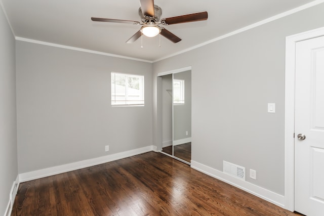 unfurnished bedroom with dark wood-type flooring, ceiling fan, and crown molding