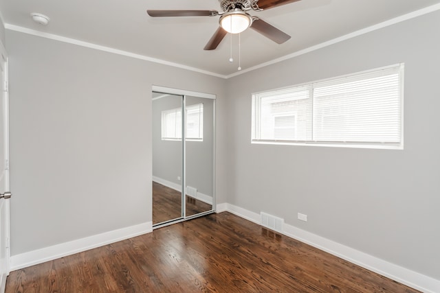 unfurnished bedroom with ornamental molding, a closet, ceiling fan, and dark hardwood / wood-style floors