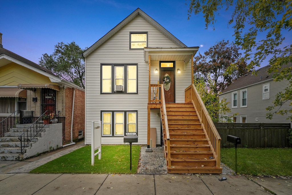 view of front of home featuring cooling unit and a yard