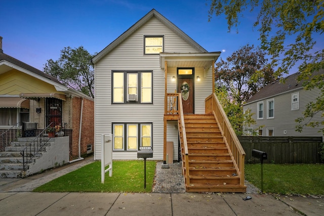 view of front of home featuring cooling unit and a yard