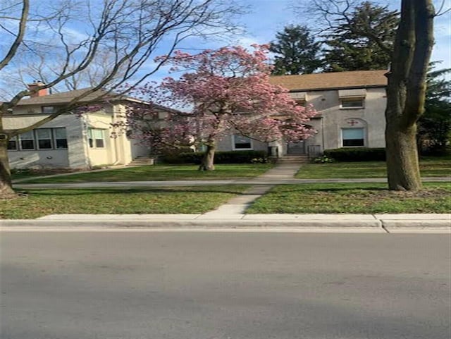 2206 W Lunt Ave, Chicago, IL 60645 - view of front of property with a front yard and stucco siding